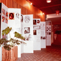 In addition to the exhibit, there are many things going on in this photograph of importance. First of all, this is one of the few photographs that capture the Mexican brick flooring that was in the 1968 addition to the library. It was made by Acme Brick Co. for O'Neil Ford and was called "el Fordo". The wall of chip carvings was made by Lynn Ford, brother of O'Neil Ford and well-known for his woodcarvings and metal work.