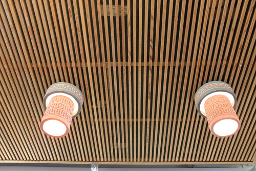 Pottery lamps hang from wooden stick suspended ceiling at the Emily Fowler Library.