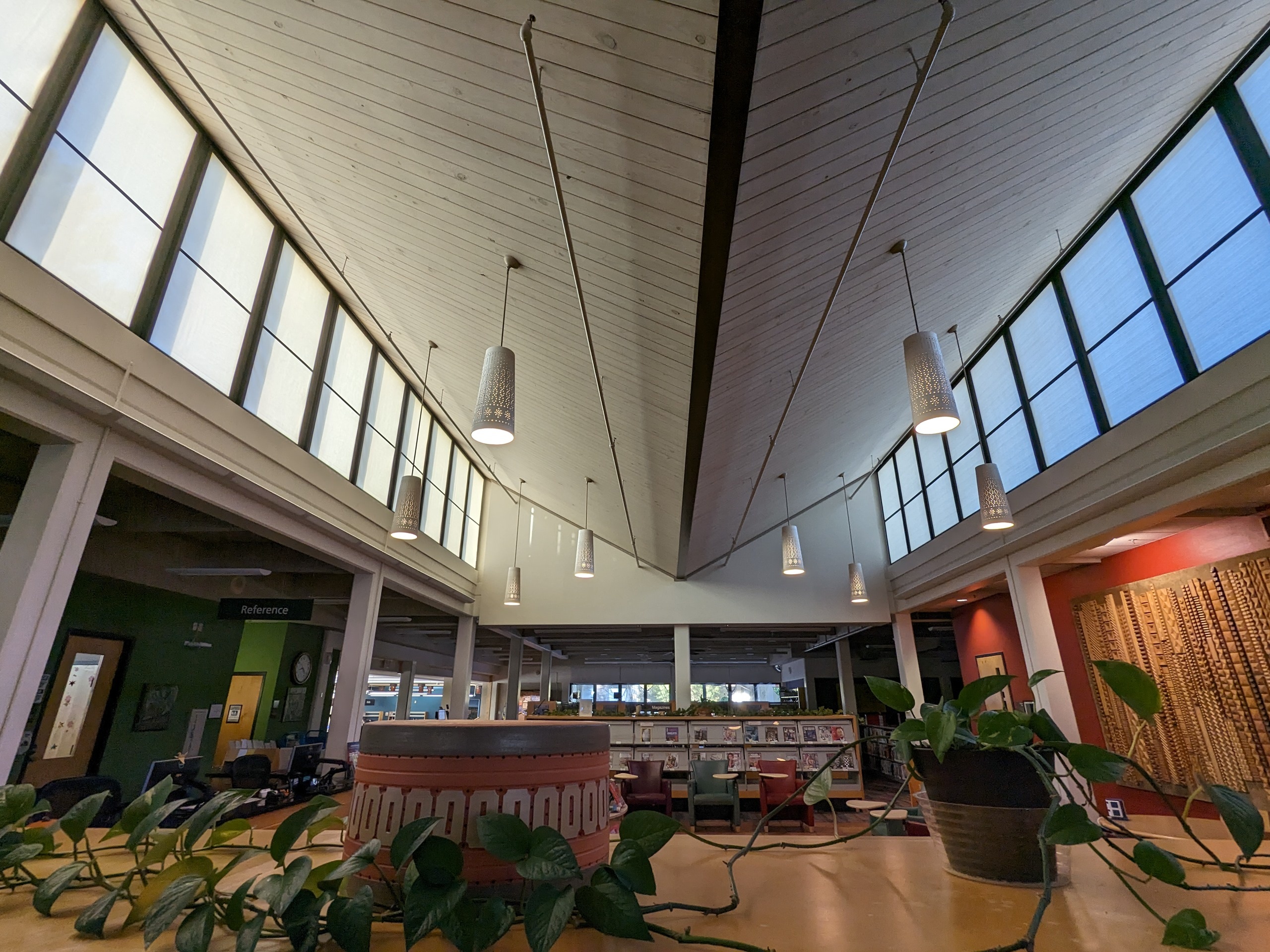 Photo of the Beaumont Mood pendant light fixtures at the Emily Fowler Library. They are painted white and hang in the middle of the upper level.