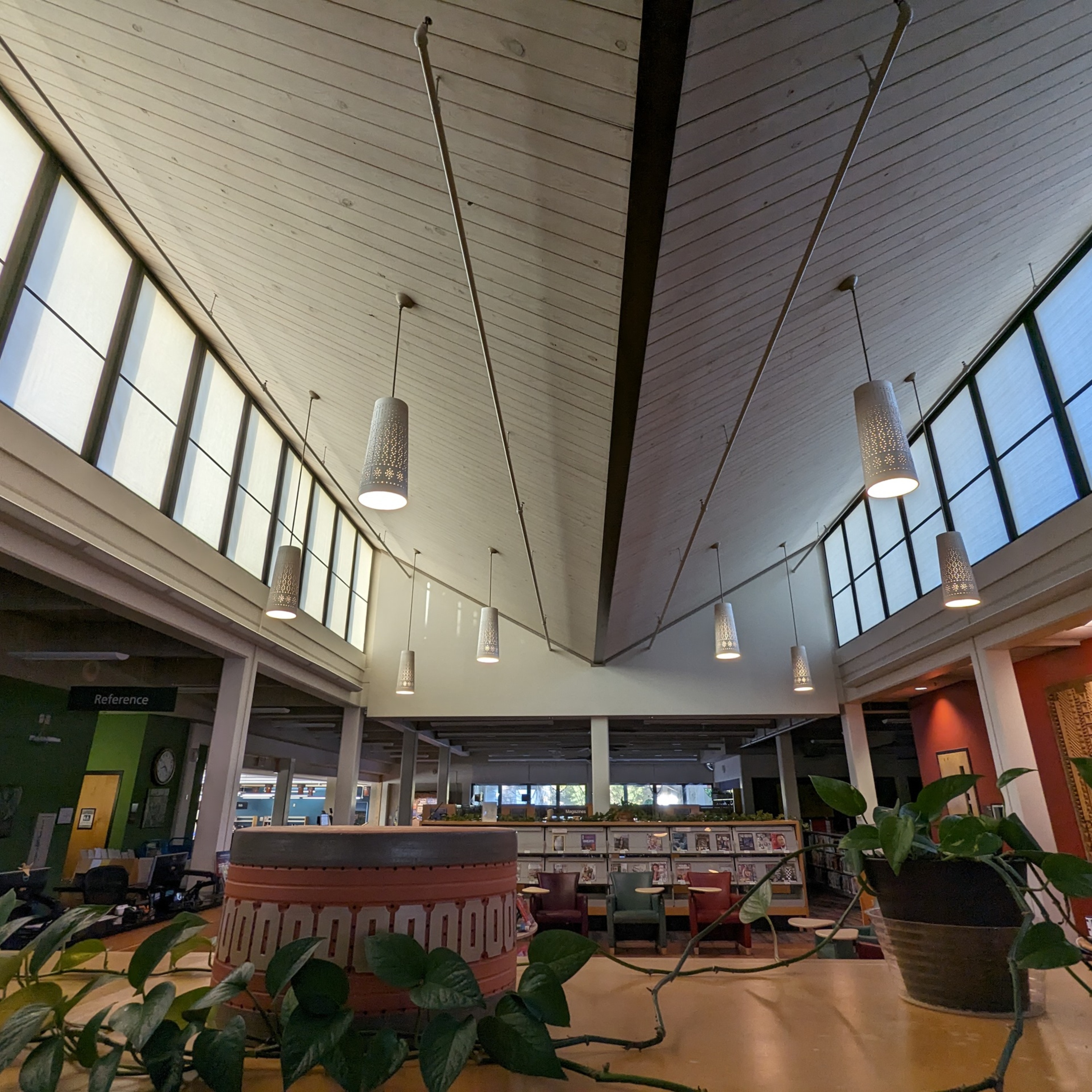 Photo of the Beaumont Mood pendant light fixtures at the Emily Fowler Library. They are painted white and hang in the middle of the upper level.